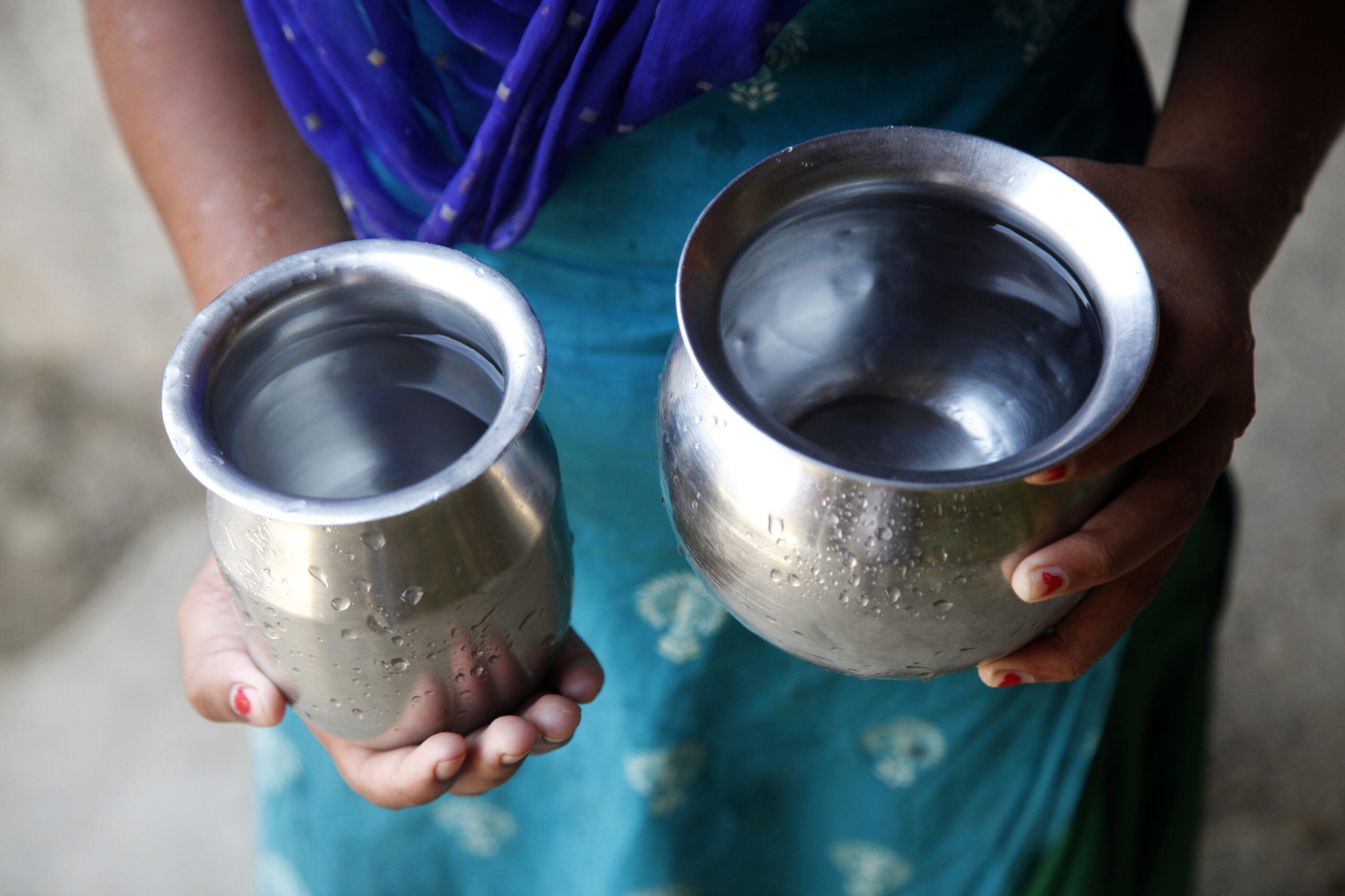 Mina Kumari Mahato, 14, holding small steel lota, she uses for drinking water, at home in Khapani Tol, Lahan-24, Nepal, April 2021.